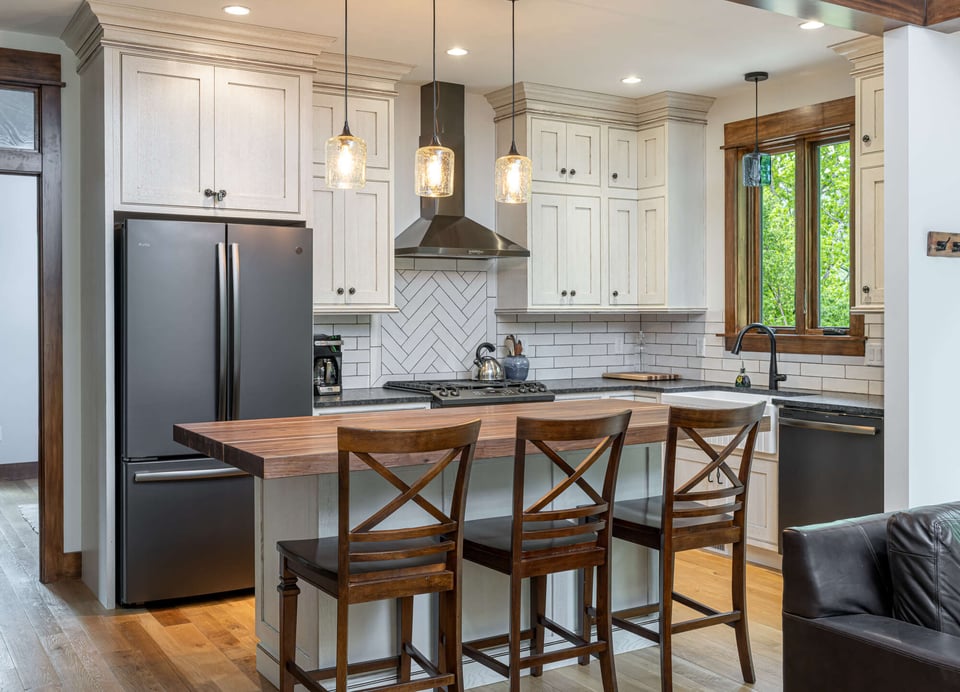 Bright kitchen interior with hardwood floors and wood finishes by Kaizen Homes