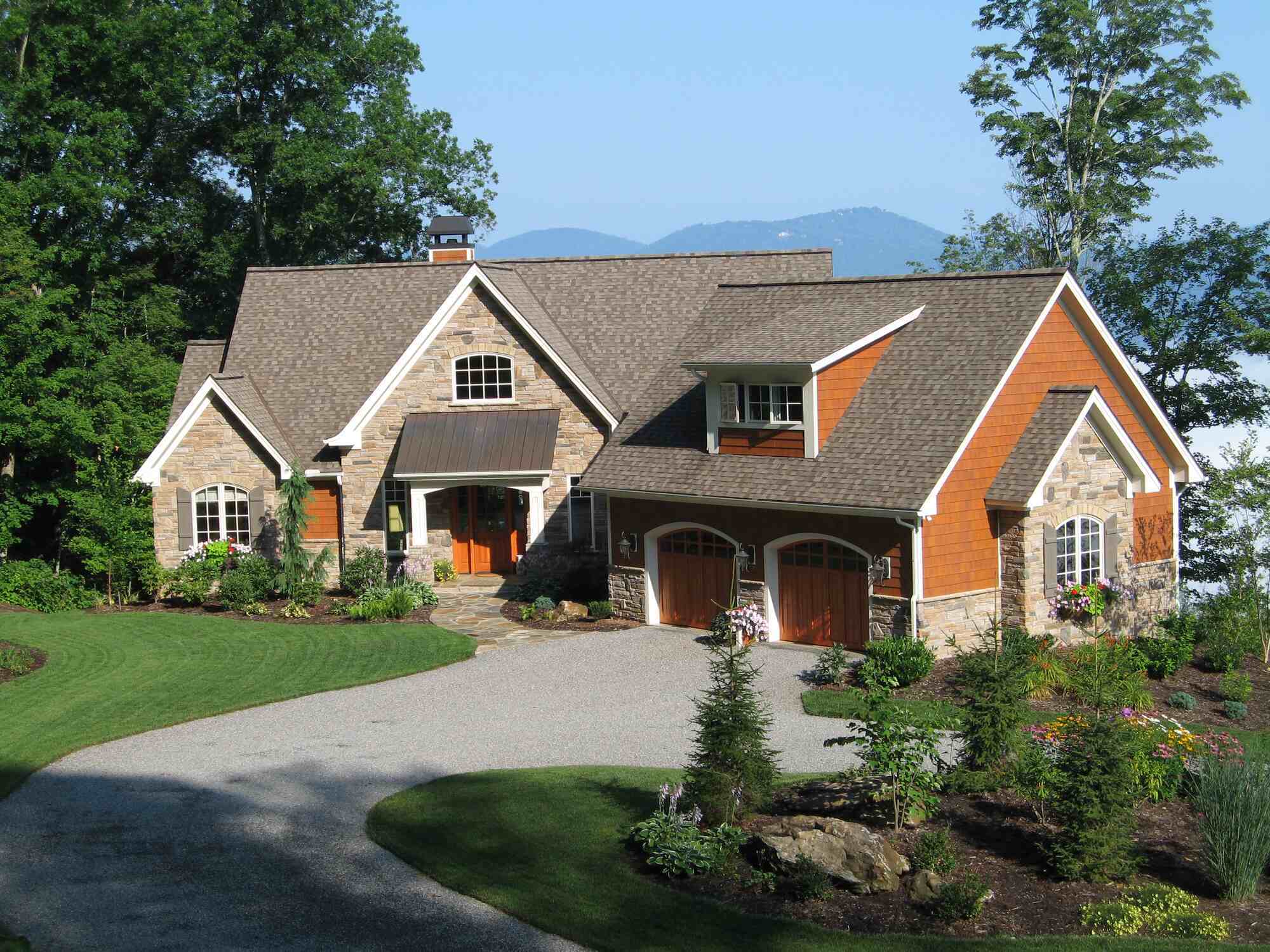 Stone and cedar custom home with mountain backdrop by Kaizen Homes in Waynesville, NC