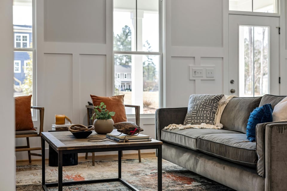 Stylish sitting area with gray couch and natural light by Kaizen Homes in Weaverville, NC