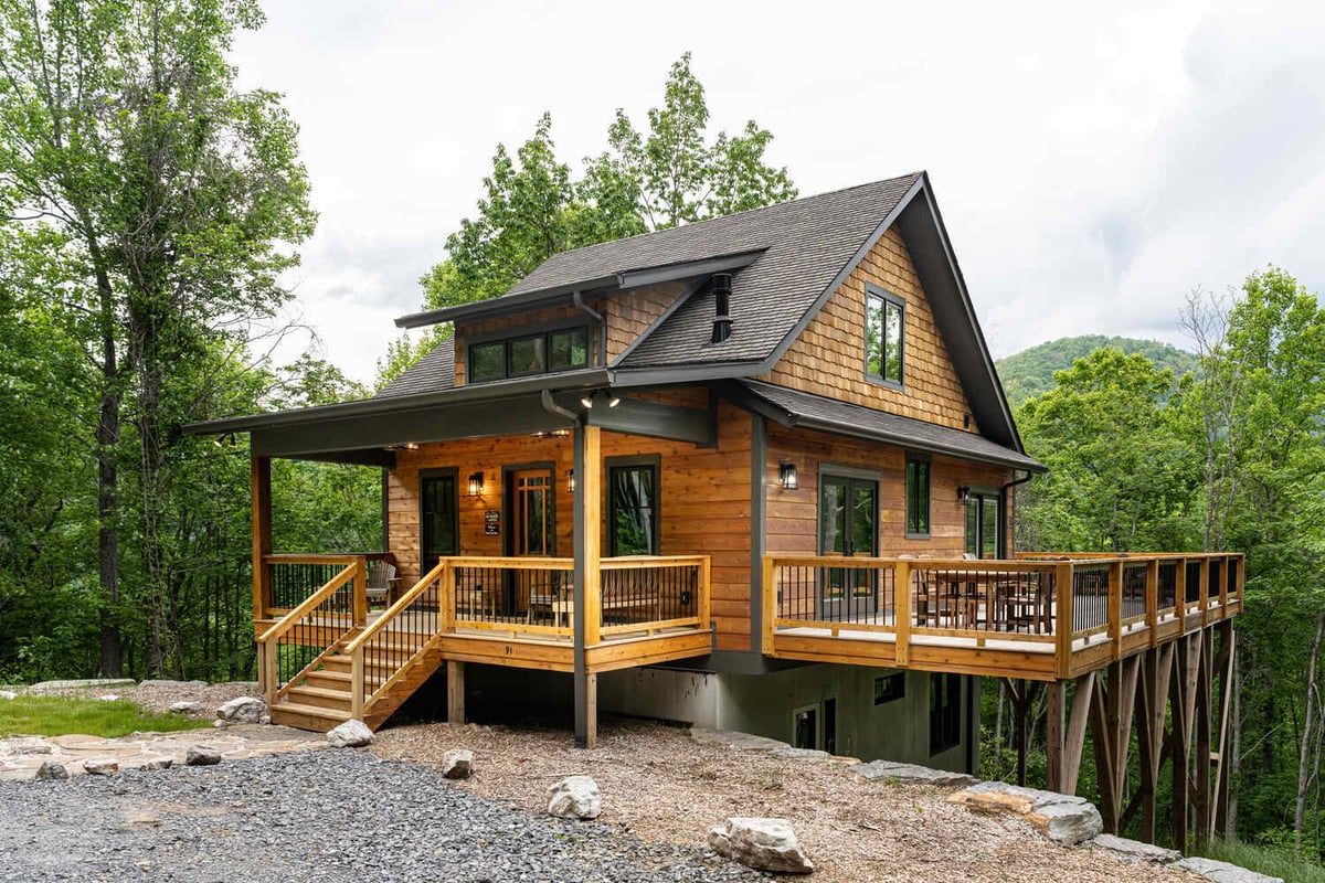 Angled exterior view of a Kaizen Homes mountain cabin with scenic backdrop