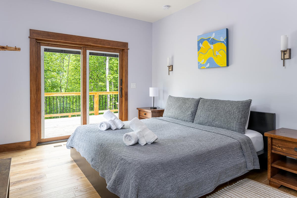 Bright and airy master bedroom with nature views by Kaizen Homes in Barnardsville