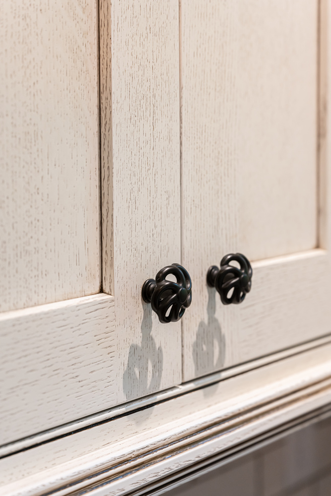 Closeup of dark metal cabinet knobs on custom cabinetry by Kaizen Homes in Montreat