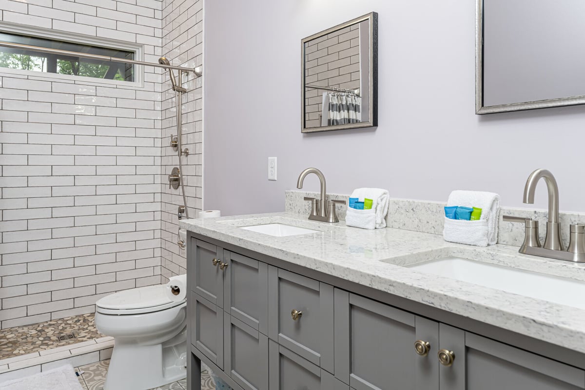 Custom bathroom remodel with double sink vanity and walk-in tiled shower by Kaizen