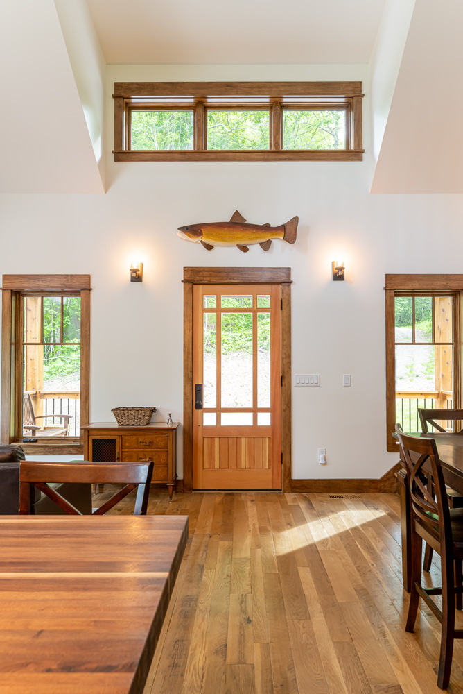 Custom front entryway with wood door and transom windows in a Kaizen Homes project