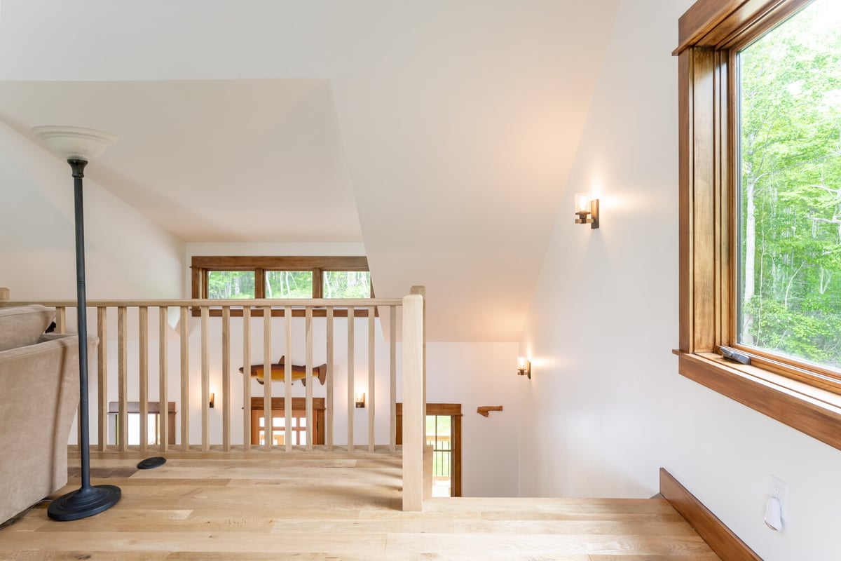 Custom staircase overlook with natural wood railing by Kaizen Homes in Waynesville