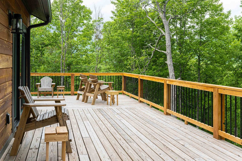 Expansive wooden deck with Adirondack chairs by Kaizen Homes in Black Mountain, NC