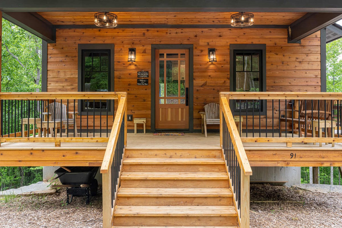 Front view of custom-built mountain cabin with wood siding and wide staircase