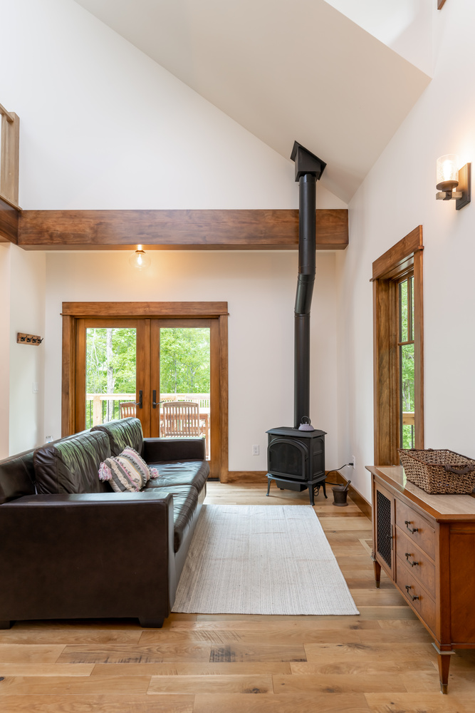 Living area with black leather sofa and wood-burning stove in a custom build