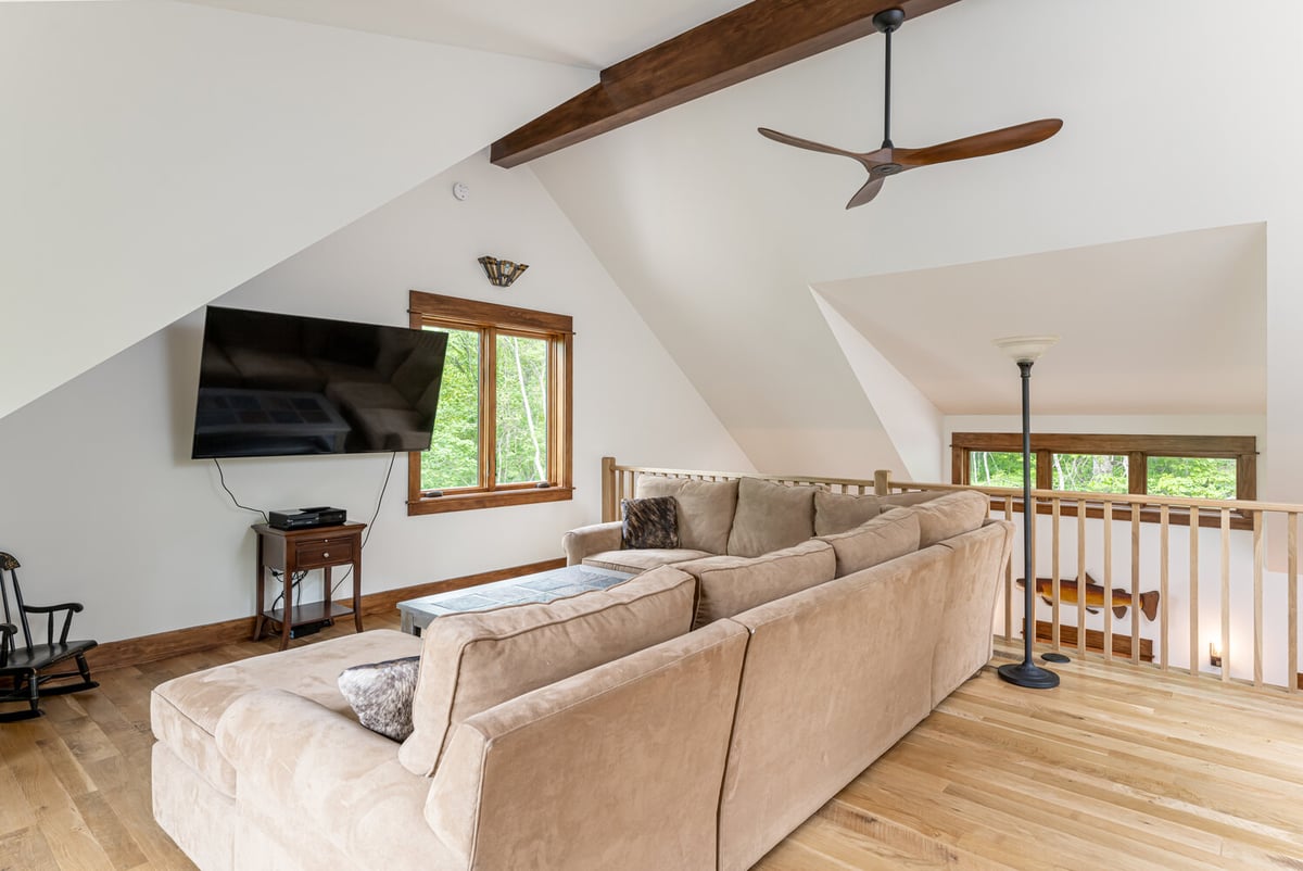 Open loft with TV and ceiling fan design by Kaizen Homes in Brevard, NC