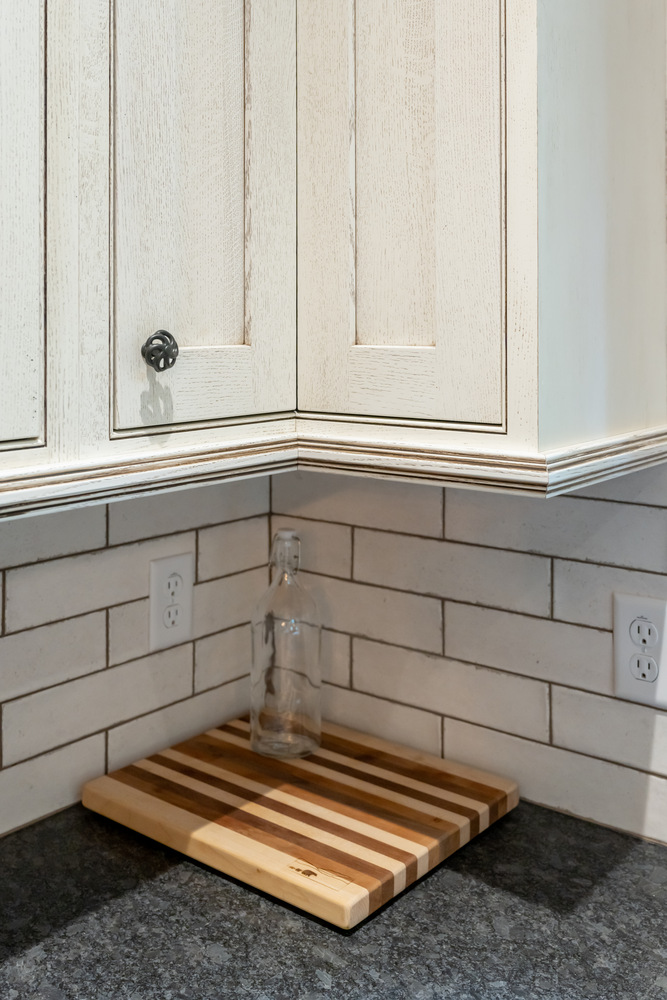White cabinetry with wood accents and custom backsplash in a Marshall, NC home