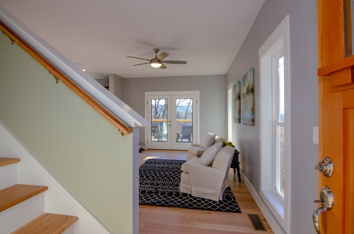 Bright living room with double French doors and accent rug by Kaizen Homes in Canton