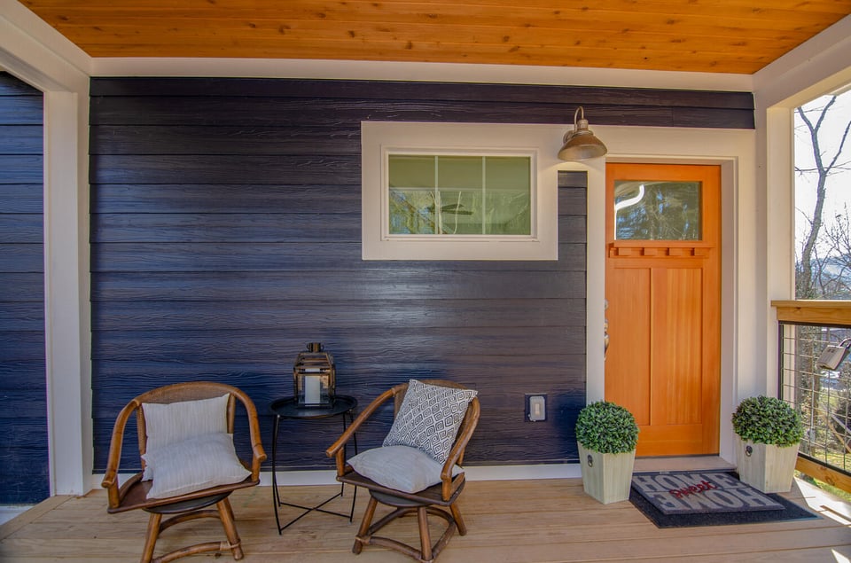 Cozy front porch seating with natural wood elements by Kaizen Homes in Canton, NC