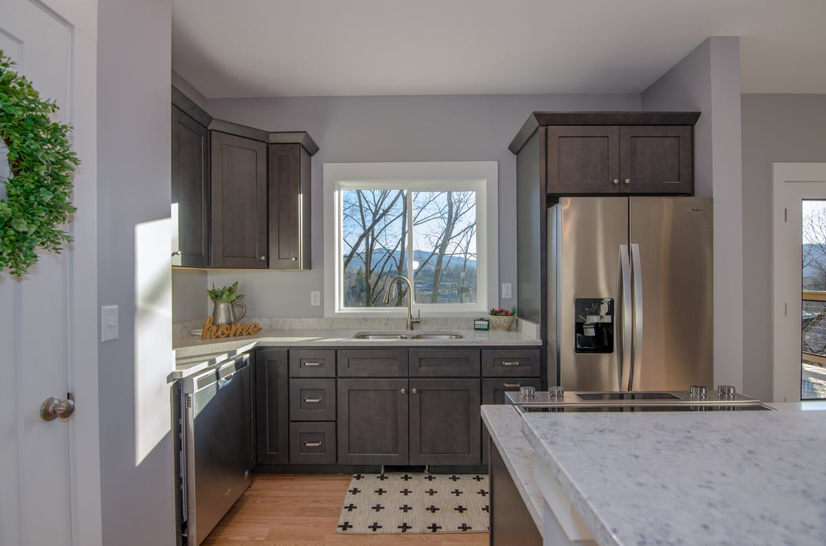 Kitchen sink with window view and dark cabinetry by Kaizen Homes in Canton, NC