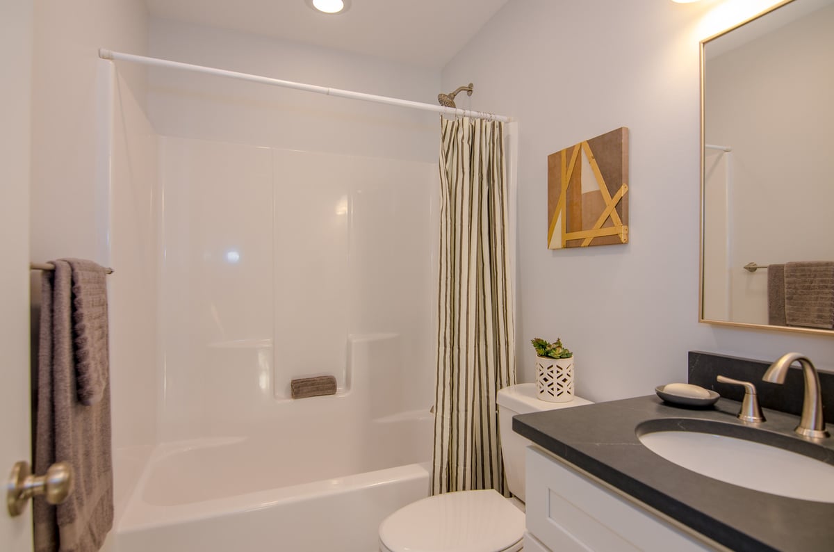 Stylish bathroom design featuring striped curtain by Kaizen Homes, Canton, NC