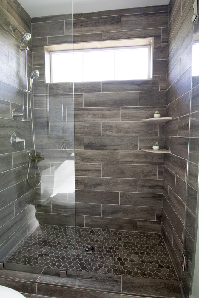Modern glass-enclosed shower with wood-look tile by Kaizen Homes in Canton, NC