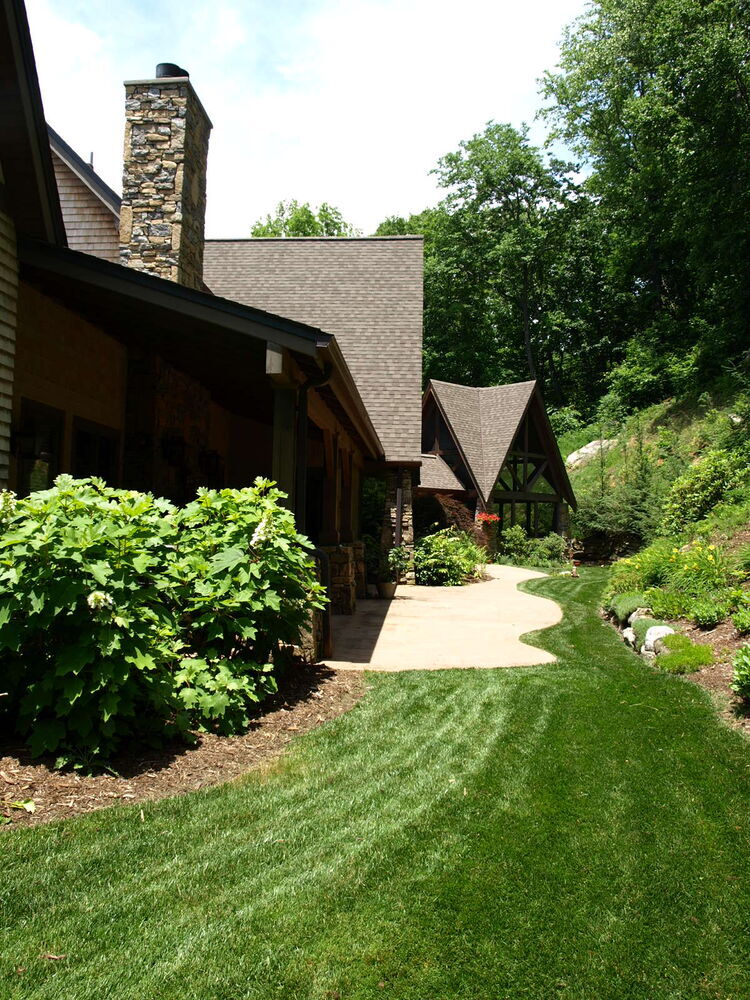 Rear side landscaping with forest backdrop by Kaizen Homes in Woodfin, NC