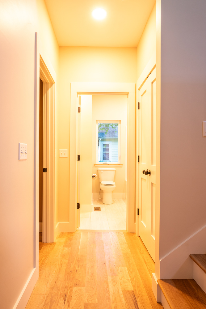 Bright corridor showing bathroom entrance and clean white trim in a Kaizen Homes