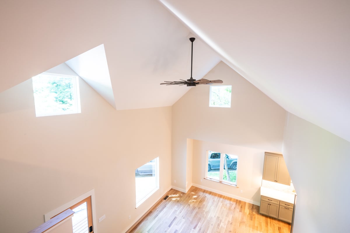 Custom home interior with natural lighting and overhead fan by Kaizen Homes