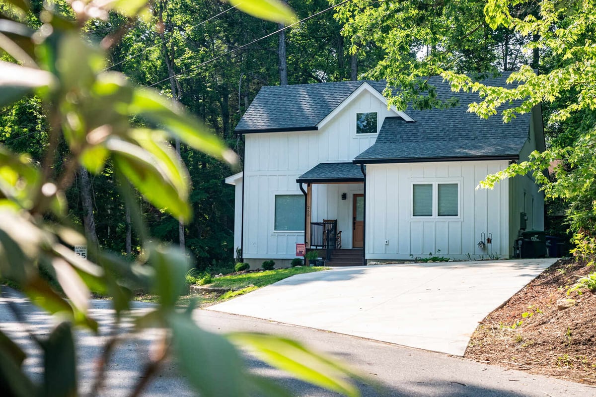 Framed view of Kaizen Homes’ custom white house in Black Mountain, NC