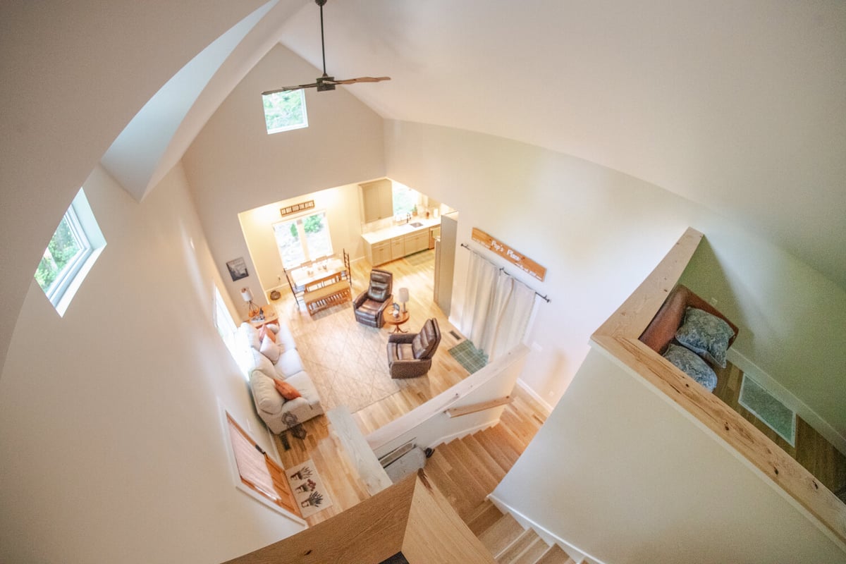 High-ceiling living room and kitchen design by Kaizen Homes in Black Mountain, NC
