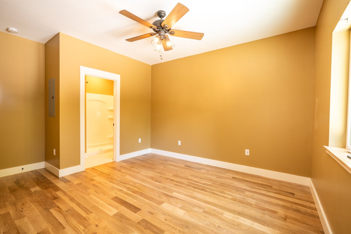 Kaizen Homes custom home bedroom with mustard walls and connected bathroom
