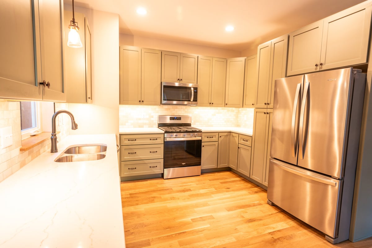 Modern kitchen with shaker cabinets and stainless appliances by Kaizen Homes