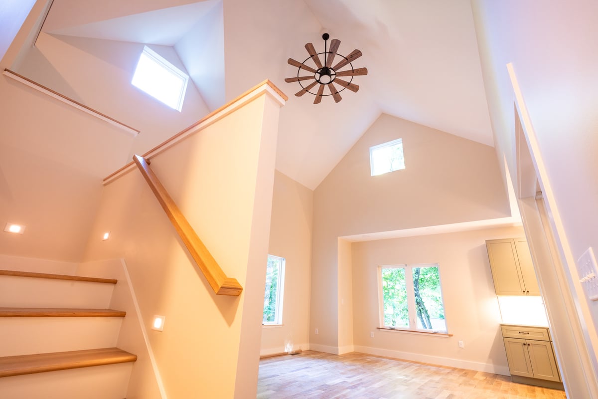 Wood staircase and vaulted ceiling in light-filled Kaizen Homes project