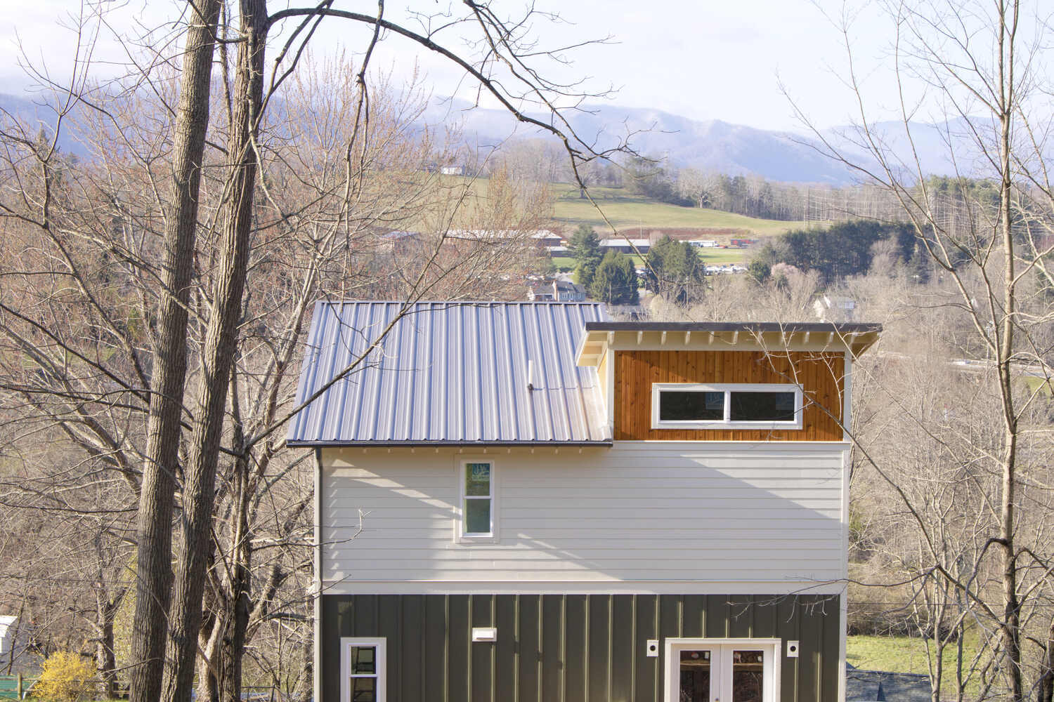 Rear view of modern custom home by Kaizen Homes in Asheville, NC with mountain backdrop