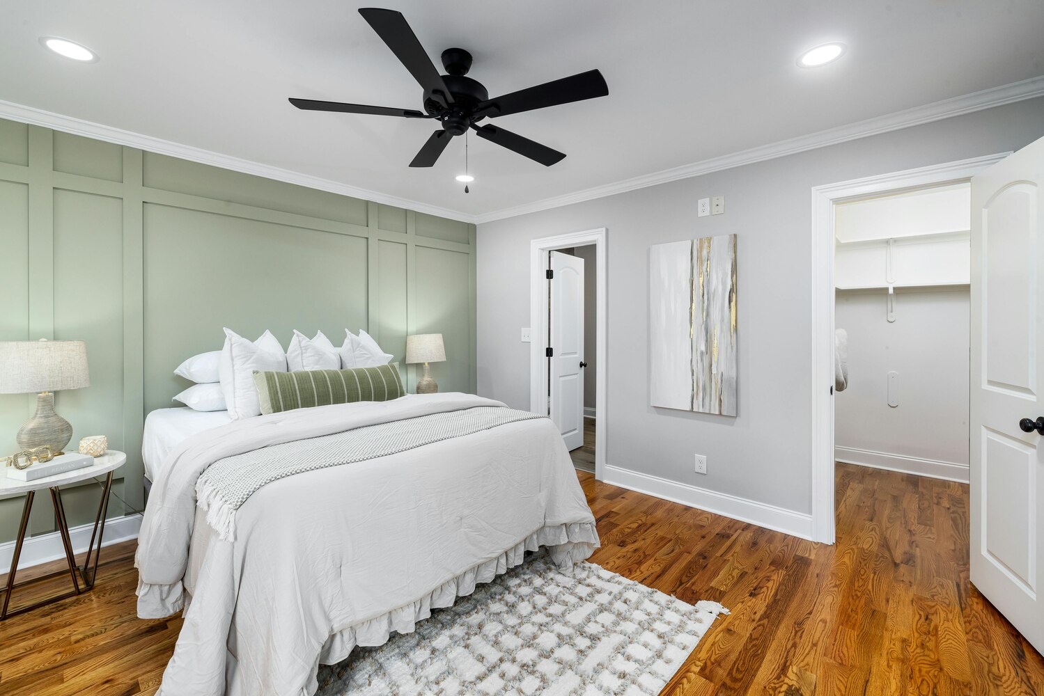 Elegant bedroom with sage green accent wall in a Kaizen Homes custom home in Waynesville, NC