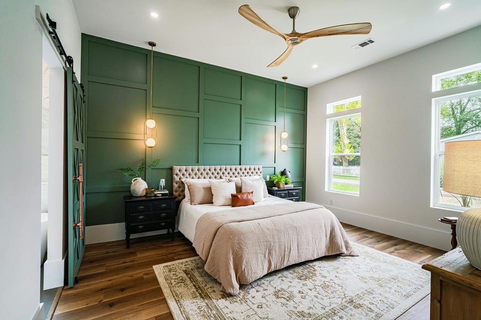 Modern bedroom with green accent wall and pendant lighting by Kaizen Homes in Brevard, NC