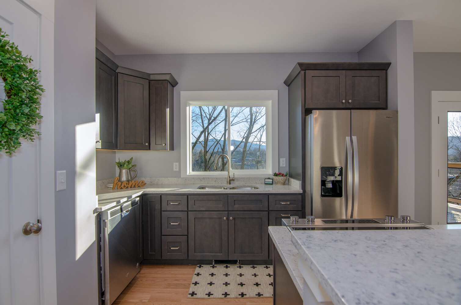 Kitchen sink with window view and dark cabinetry by Kaizen Homes in Canton, NC
