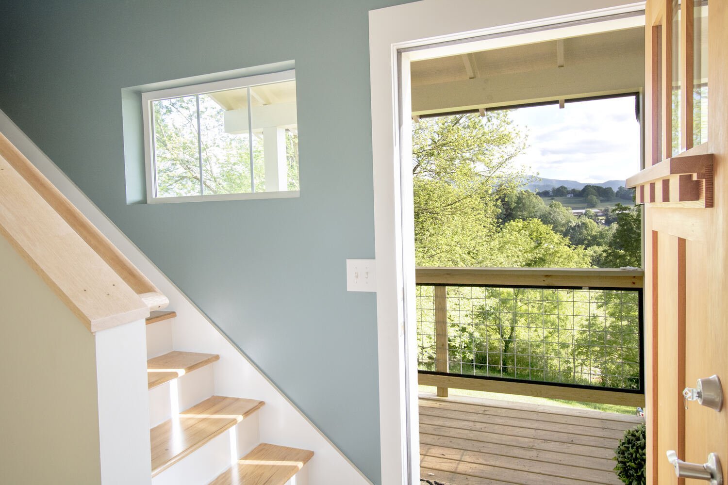 Entry area with staircase and natural lighting by Kaizen Homes in Canton, NC