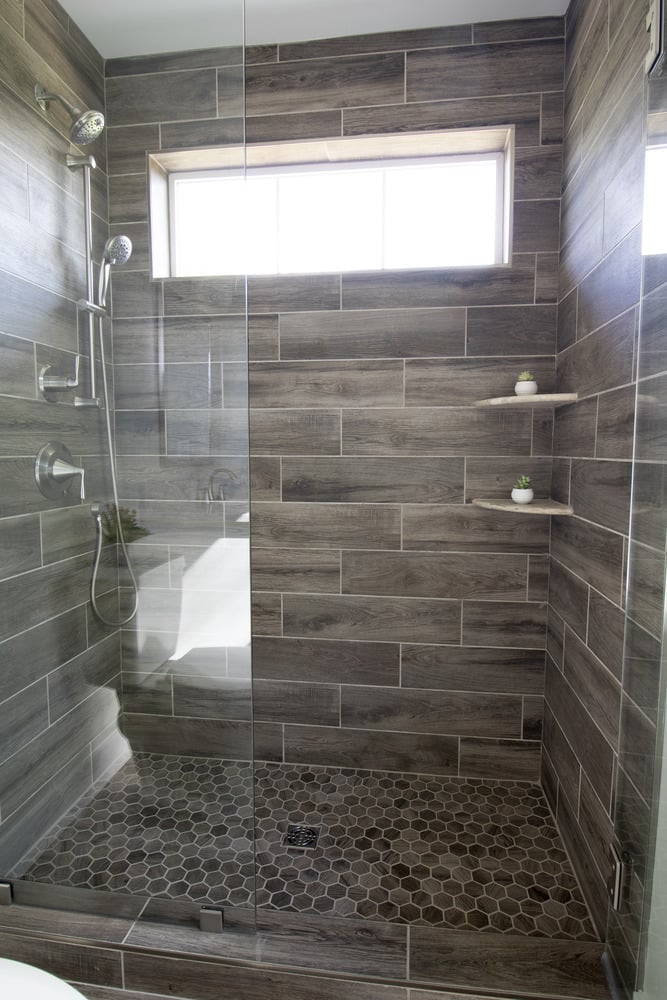 Modern glass-enclosed shower with wood-look tile by Kaizen Homes in Canton, NC