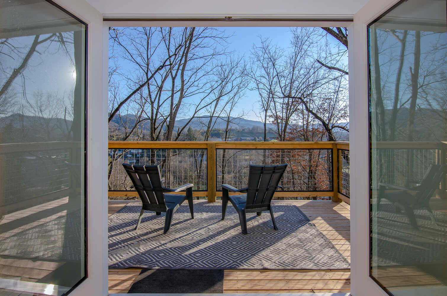Outdoor deck with lounge chairs and railing in a Kaizen Homes build in Waynesville, NC