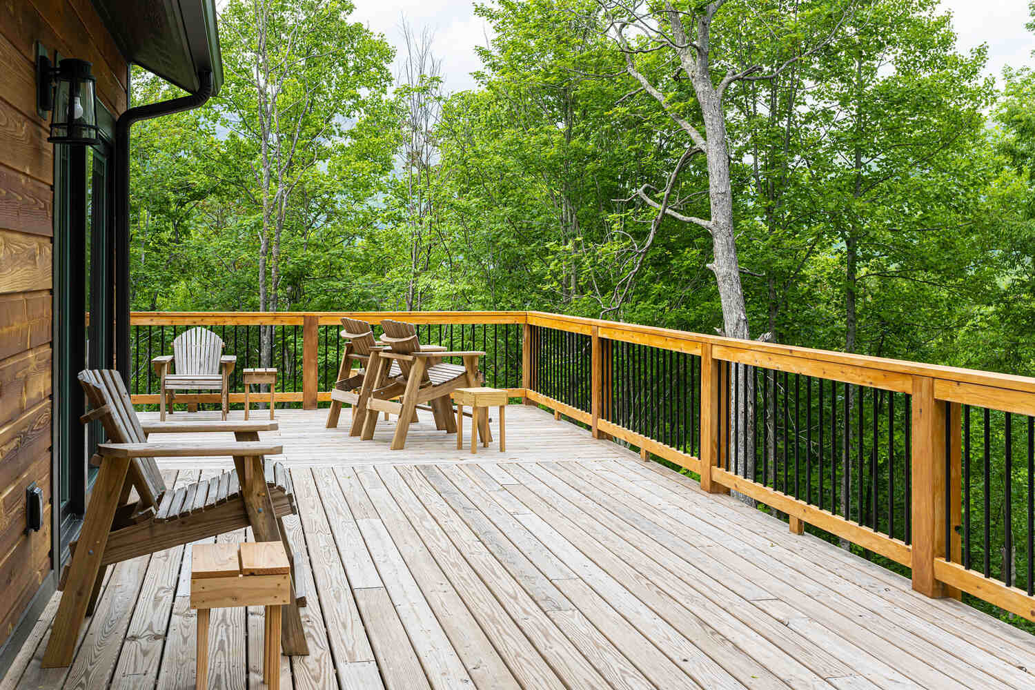 Wood deck with forest views at custom cabin home in Canton, NC by Kaizen Homes