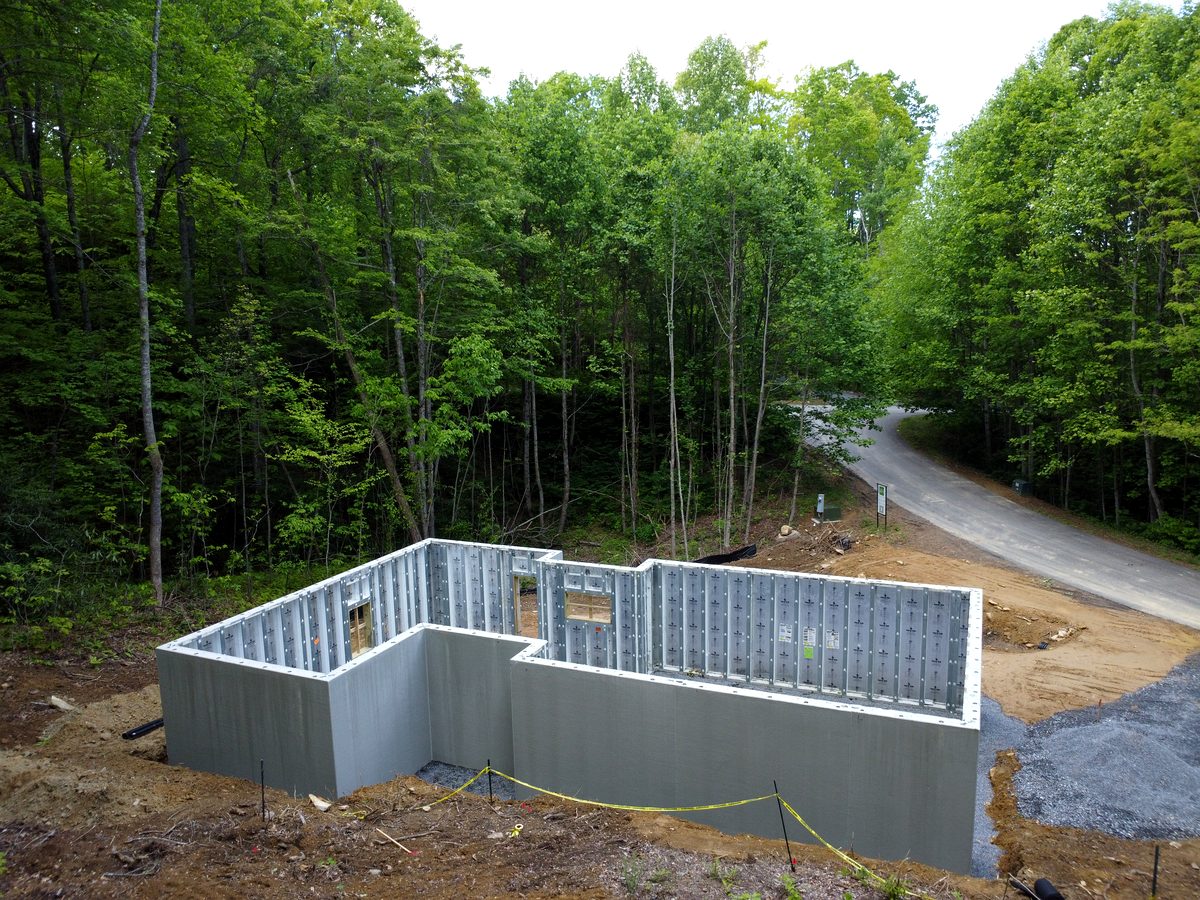Aerial view of Superior Walls walk-out basement foundation on WNC mountain lot — Kaizen Homes